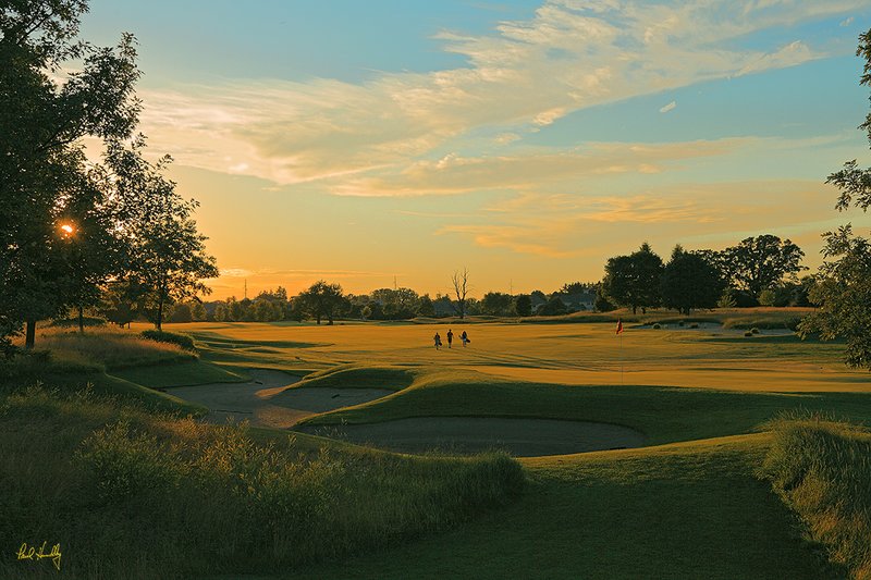 B104--1156  1200px  V1  SS1.jpg :: The 11th hole at The Legend at Bristlecone Pines with 3 yound golfers silhouetted against the setting sun.  Bristlecone Pines is located in Hartford, Wisconsin.  July, 2010; PM shoot.  Photograph by Paul Hundley.
