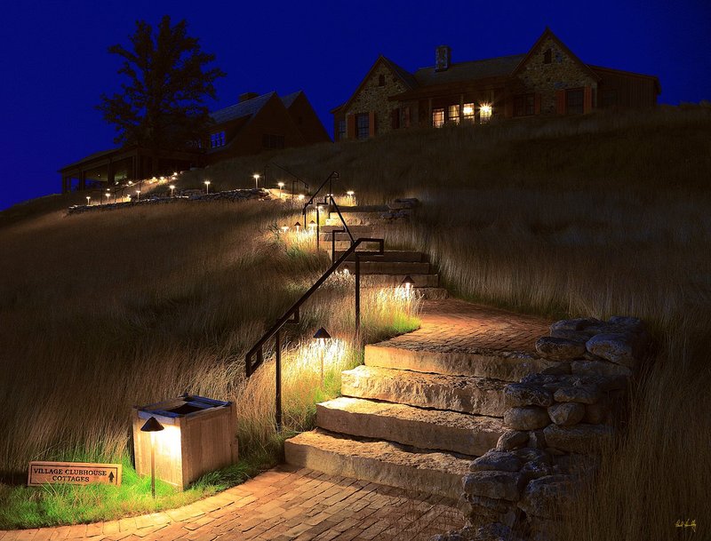 E101--0067  1200px  with signature  V4  SS.jpg :: The lighted walk from the lodge and pro shop up to the main clubhouse and cottages at dusk at Erin Hills, a daily fee golf course in Erin, Wisconsin.  Erin Hills was designed by Hurdzan/Fry and Ron Whitten and built by Landscapes Unlimited, LLC.  Photograph by Paul Hundley; July, 2010;