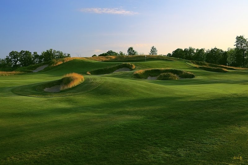 E101--1552  1200px with signature  V2  SS.jpg :: The tee shot landing area and green complex of the short par 4 fifteenth hole at Erin Hills.  Erin Hills is a daily fee golf course in Erin, Wisconsin.  It was designed by Hurdzan/Fry Designs and Ron Whitten and built by Landscapes Unlimited, LLC.  Photograph by Paul Hundley; July, 2011.