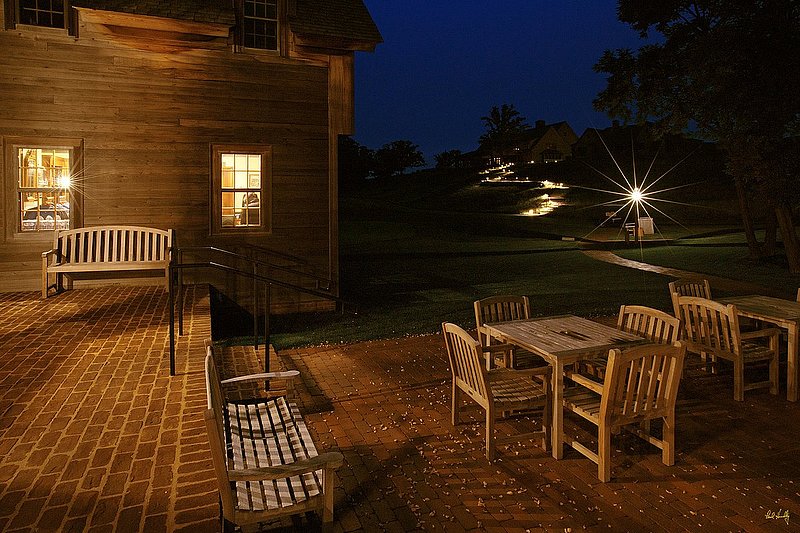 E101--Lodge 001  V1  1500px  SS - with signature.jpg :: Exterior view of the courtyard at night outside The Lodge at Erin Hills, a daily fee golf course in Erin, Wisconsin.  Erin Hills was designed by Hurdzan/Fry and Ron Whitten and built by Landscapes Unlimited, LLC, and has been choosen to host the 2011 US Amateur Chanpionship and the 2017 US Open Championship.  Photo by Paul Hundley; taken in September, 2012.