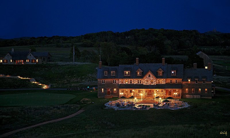 E101--Lodge 006  V1  1500px  SS - with signature1.jpg :: The Lodge and lower patio with the putting green to the left and one of the 4 bedroom cabins (above left) at Erin Hills.  Holy Hill, a local landmark and nationally-known Carmelite Shrine built on the hightest point in southern Wisconsin, is also visible in the upper right corner.  Erin Hills is a daily fee golf course in Erin, Wisconsin.  Erin Hills was designed by Hurdzan/Fry and Ron Whitten and built by Landscapes Unlimited, LLC, and has been choosen to host the 2011 US Amateur Chanpionship and the 2017 US Open Championship.  Photo by Paul Hundley; taken in September, 2012.