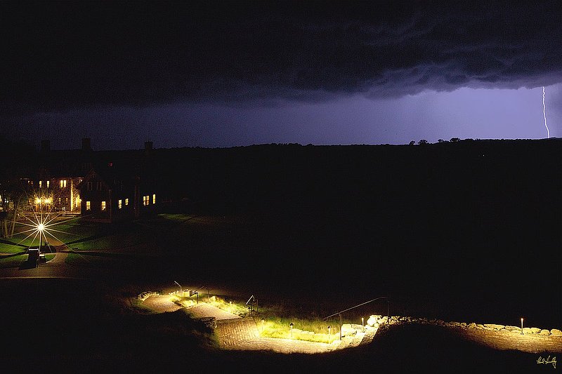 E101--Lodge 03  V1  1500px  with signature  SS.jpg :: An approaching thunderstorm over The Lodge (lower left) and the walk leading up to the Village Clubhouse at Erin Hills, a daily fee golf course in Erin, Wisconsin.  Erin Hills was designed by Hurdzan/Fry and Ron Whitten and built by Landscapes Unlimited, LLC, and has been choosen to host the 2011 US Amateur Chanpionship and the 2017 US Open Championship.  Photo by Paul Hundley; taken in September, 2012.
