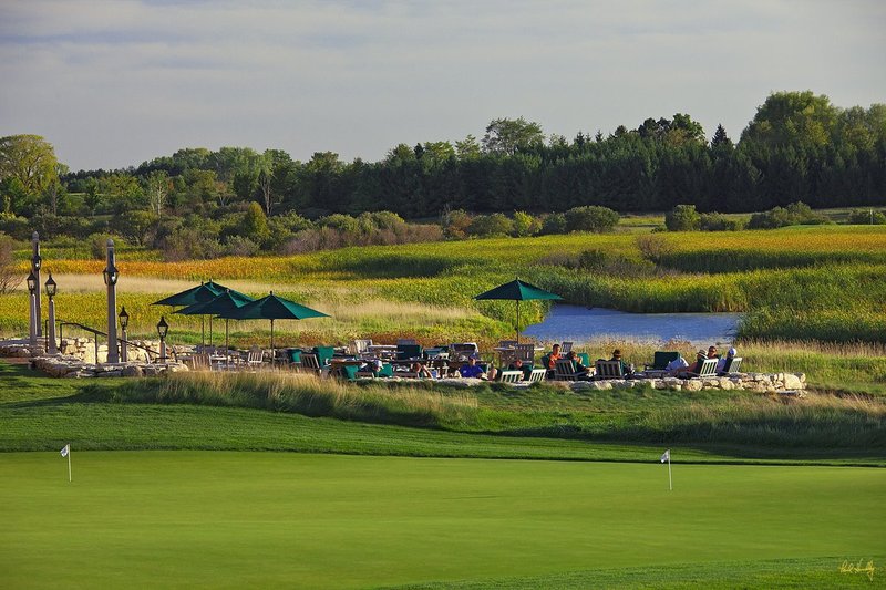 E101--Lodge 17  V1  1500px  SS - with signature.jpg :: Players relax and participate in a buffet spread after their round at Erin Hills, a daily fee golf course in Erin, Wisconsin.  Erin Hills was designed by Hurdzan/Fry and Ron Whitten and built by Landscapes Unlimited, LLC, and has been choosen to host the 2011 US Amateur Chanpionship and the 2017 US Open Championship.  Photo by Paul Hundley; taken in September, 2012.