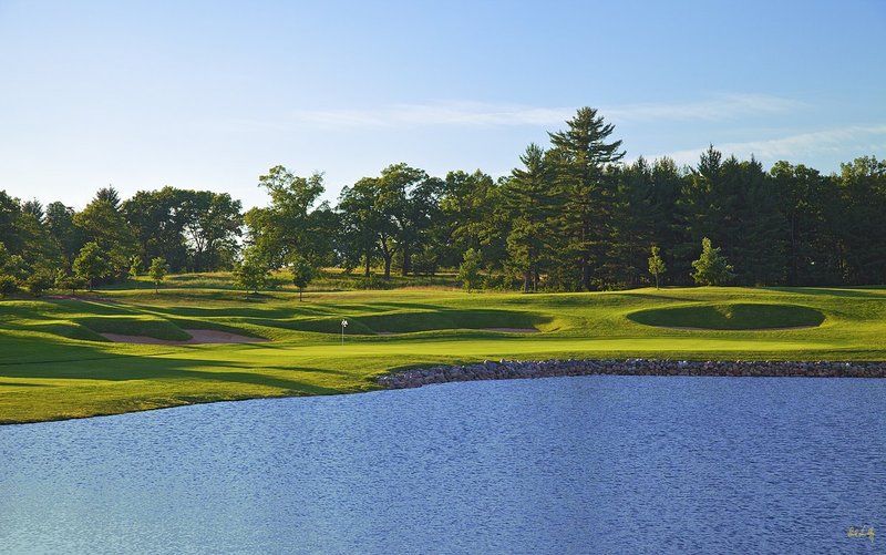 N103--1856  V1  1500px  SS (with signature).jpg :: The par 5 finishing hole at The Castle Course at Northern Bay Resort, a public resort golf club located in Arkdale, WIsconsin.  The Castle Course is a mix of original holes and replicas of some of America's most famous golf holes.  This hole is a replica of the eighteenth hole at Arnold Palmer's Bay Hill Club.  June,  2011; PM shoot.  Photograph by Paul Hundley.