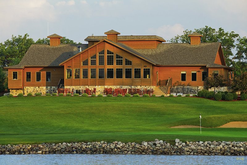 N103--1860  V1  1500px  SS (with signature).jpg :: The clubhouse sits above the green on the par 5 finishing hole at The Castle Course at Northern Bay Resort, a public resort golf club located in Arkdale, WIsconsin.  The Castle Course is a mix of original holes and replicas of some of America's most famous golf holes.  The eighteenth is a replica of the eighteenth hole at Arnold Palmer's Bay Hill Club.  June,  2011; AM shoot.  Photograph by Paul Hundley.