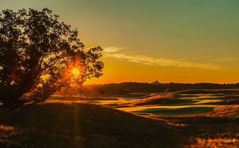 E101--0766  V1  1200px  SS  with signature.jpg :: Sunrise over the par five 7th green and the par five 18th hole (with the Carmalite Bascilica, known locally as \