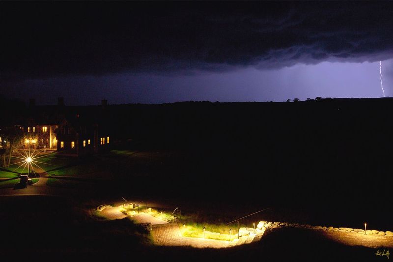 E101--Lodge 03  V1  1500px  with signature  SS1.jpg :: An approaching thunderstorm over The Lodge (lower left) and the walk leading up to the Village Clubhouse at Erin Hills, a daily fee golf course in Erin, Wisconsin.  Erin Hills was designed by Hurdzan/Fry and Ron Whitten and built by Landscapes Unlimited, LLC, and has been choosen to host the 2011 US Amateur Chanpionship and the 2017 US Open Championship.  Photo by Paul Hundley; taken in September, 2012.